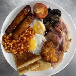 The airport diner large brakfast Sausages, Bacon, Potato Bread, Egg, Hash Brown/Soda Bread, Tomato, Baked Beans, Toast served with a Pot of Tea or Coffee.