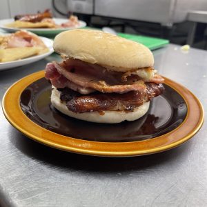 Plated classic sausage egg and bacon bap